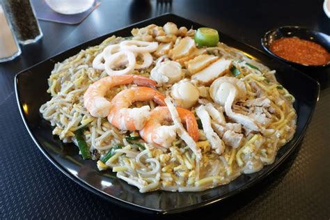  Hokkien Mee: Un connubio di sapori umami e piccantezza agrumata che ti trasporterà direttamente nella vibrante città di Sibu!